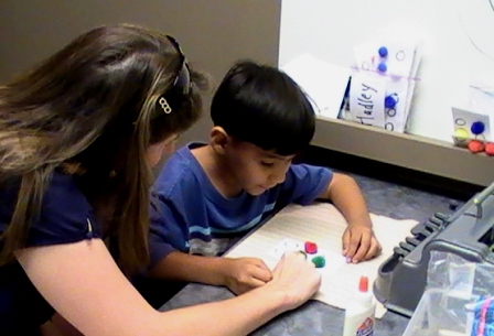 Jackie Ottwell, a BELL program instructor, works with a young student learning Braille through the use of tactile materials.